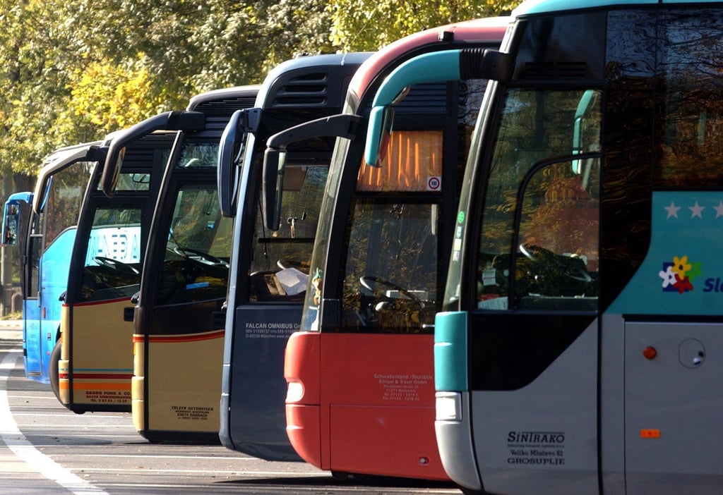 Reisebusse auf einem Parkplatz.