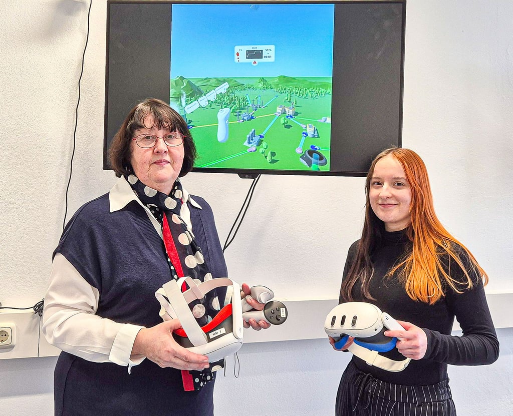 Mechthild Meinike (l.) und Charlotte Städter erklären den Studierenden und Interessierten an der Hochschule Merseburg, wie die VR-Technik funktioniert.