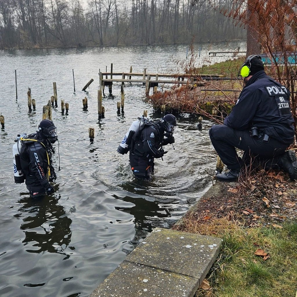 Polizeitaucher suchen nach einer Bombe im Wasser.