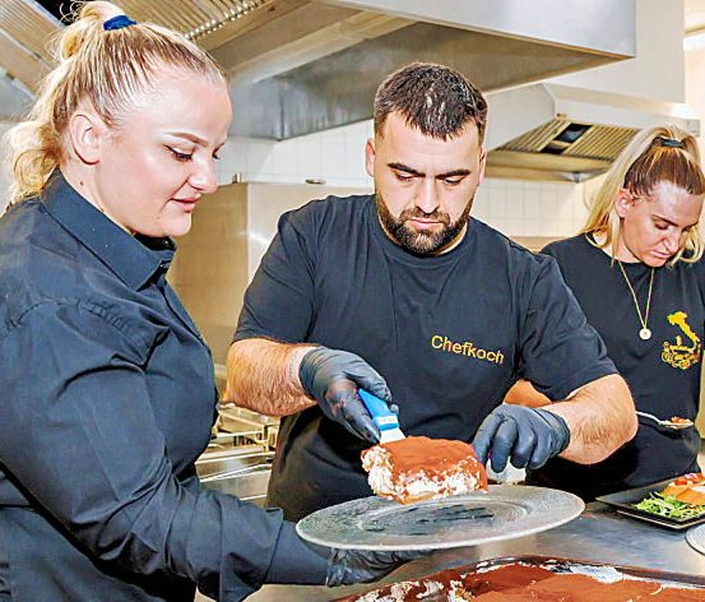 Danjela Lushag und Chefoch Marlon bereiten das frische Tiramisu zum Servieren vor.
