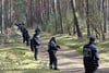 Polizisten bilden eine Kette im Wald bei Stendal. Sie suchen nach Hinweisen, wie nicht verrotette Kleidungsstücke oder Ähnliches.   