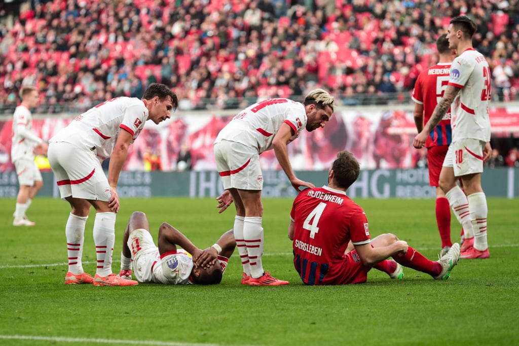 Lois Openda liegt am Kopf getroffen auf dem Boden, Kevin Kampl spricht mit Heidenheims Siersleben.