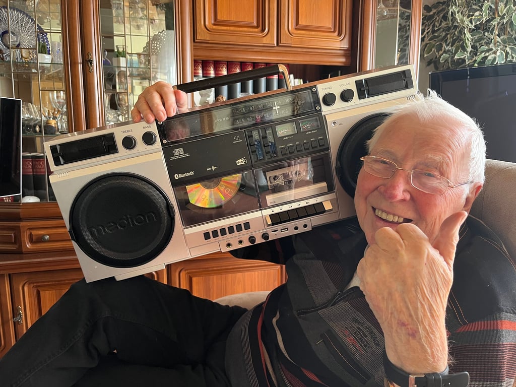 Wie früher: Der 90-jährige Hans „Scholli“ Scholz trägt ein Radio auf der Schulter.