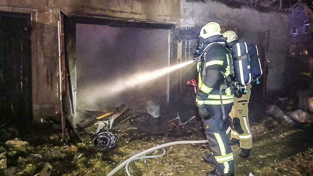 Einsatzkräfte der Oschersleber Feuerwehr bei der Brandbekämpfung im Garagenkomplex an der Hornhäuser Straße.