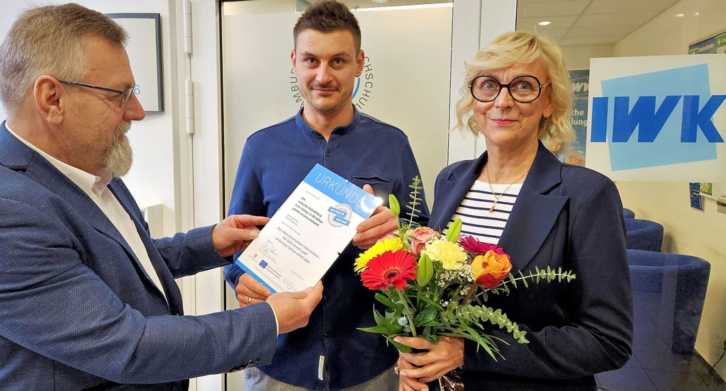 André Gottschalk übergibt die Urkunde für das IWK an Kevin Wunderling und Frauke Paasche.