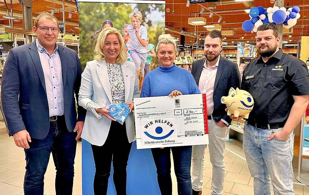 Susen Thiele (Zweite von links) nimmt den Scheck entgegen. Für die Edeka-Vertreter Stefen Wienskowski (links), Sandra Weidauer, Florian Sabais (Zweiter von rechts) und Daniel Bauduin hatte sie als Dank ein selbst gebackenes Herz dabei – ganz Kathi eben.