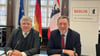 Landeswahlleiter Stephan Bröchler (links) und sein Stellvertreter Roland Brumberg sitzen an einem Tisch bei der Sitzung des Landeswahlausschusses im Roten Rathaus.