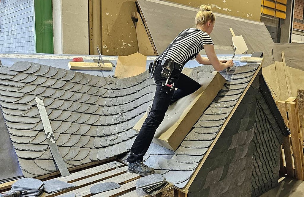 Dinah Metzner bei der Arbeit an ihrem Meisterstück. Jede Schieferplatte wird einzeln mit dem Hammer in Form gebracht.