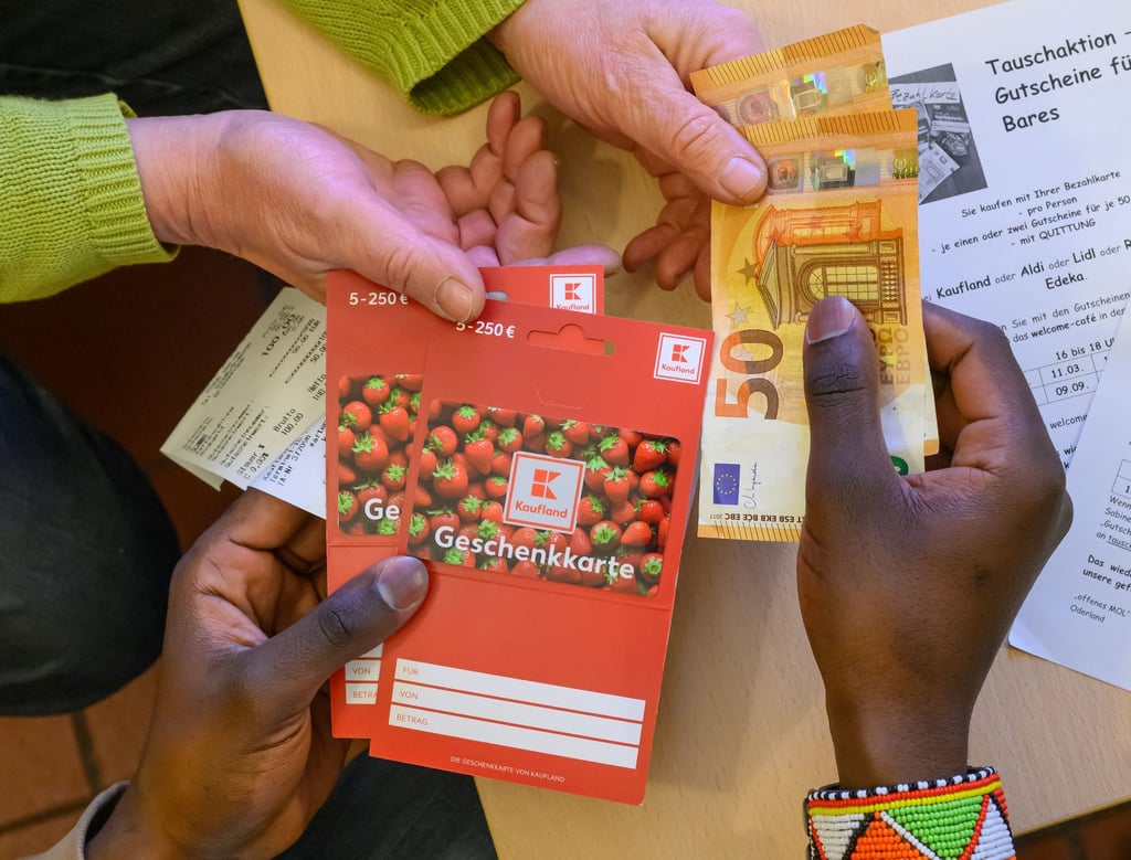 Ein Flüchtling tauscht zwei im Supermarkt gekaufte Gutscheine gegen Bargeld.