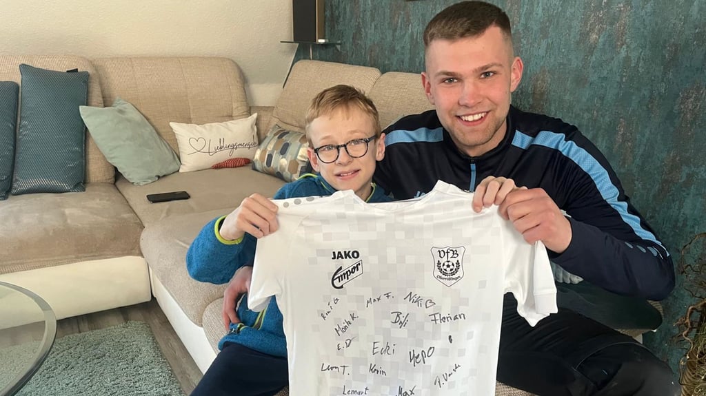 Der an Cystinose erkrankte Niklas Zelmer aus Niederröblingen bekommt von seinem Lieblingsspieler des VfB Oberröblingen, Torwart Niklas Beek, ein Trikot mit den Unterschriften der Spieler überreicht.