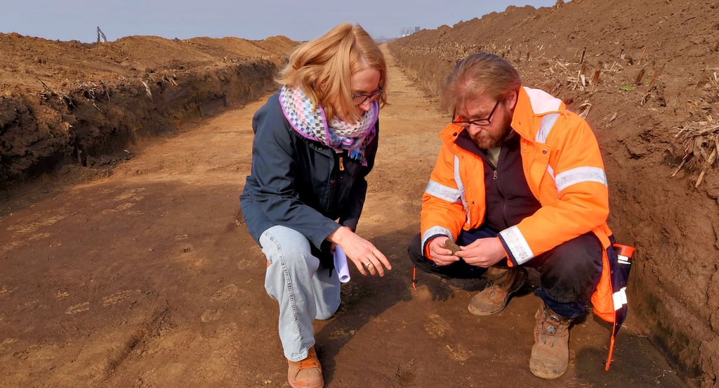 Dietlind Paddenberg und Nikita Sirman betrachten eine circa 3.000 Jahre alte Keramikscherbe, die an einer markanten Stelle gefunden wurde.