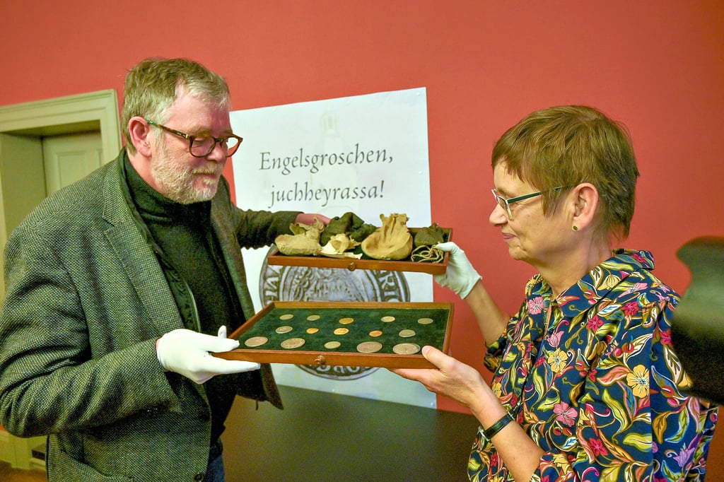 Ulf Dräger, Leiter des Landesmünzkabinetts, erhält von  Pfarrerin Iris Helmich einen Teil des Eisleber Münzschatzes.