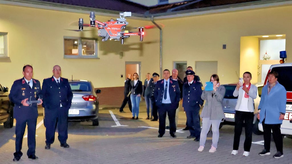 Der Eisleber Ortswehrleiter René Wunderlich (links) ließ vor dem Feuerwehrgebäude eine Drohne steigen.