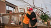 Nach dem Durchzug eines Tornados in Missouri spenden sich Freunde Trost und räumen auf.