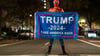 Trump-Unterstützer im Spider-Man-Kostüm mit einem Trump-Transparent am Tag der US-Präsidentschaftswahl 2024 in Washington.