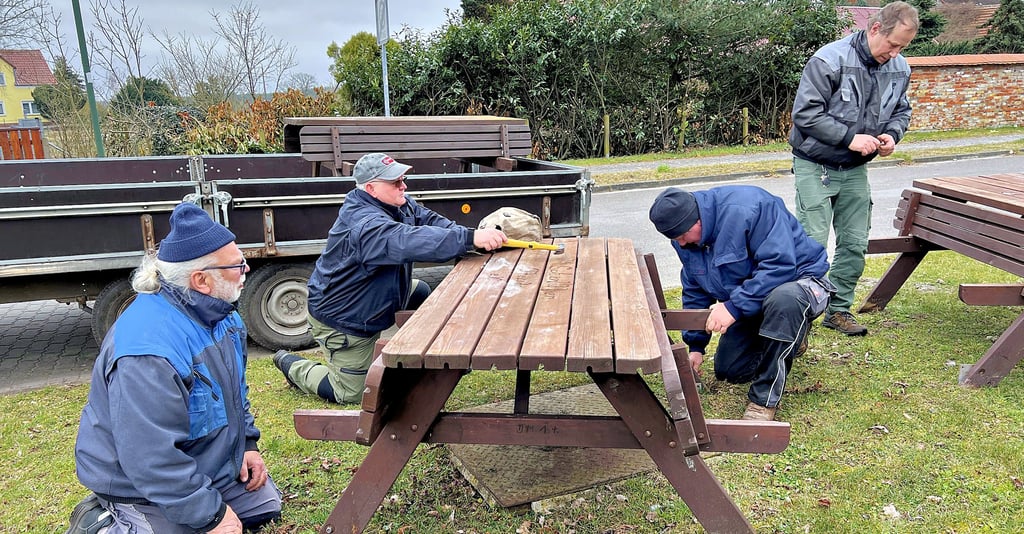 Axel Strube, Heinz Päsler, Holger Bretzke und Frank Schirmer (von links) stellen die beiden Sitzgruppen am Ehrenmal für die Rote Armee wieder auf. Eingelagert sind diese über den Winter in einer Halle der Agrargenossenschaft.