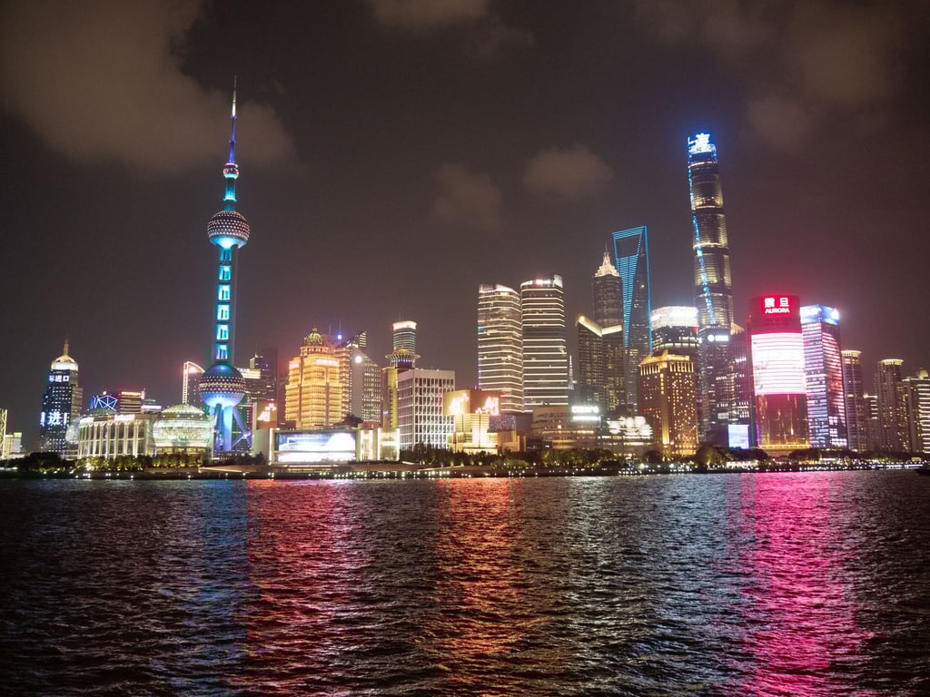Pudong auf der anderen Seite des Huangpu-Flusses: abendlicher Ausblick von Shanghais Uferpromenade The Bund aus.