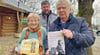 Detlef Radke (rechts), Heide Burkert und Marco Radke mit dem Buch und dem Umschlag, in dem es nach Weißewarte kam. In dem Werk  erinnert sich Deutsch-Engländerin Katrin Fitzherbert  auch an ihre Zeit in Weißewarte. 