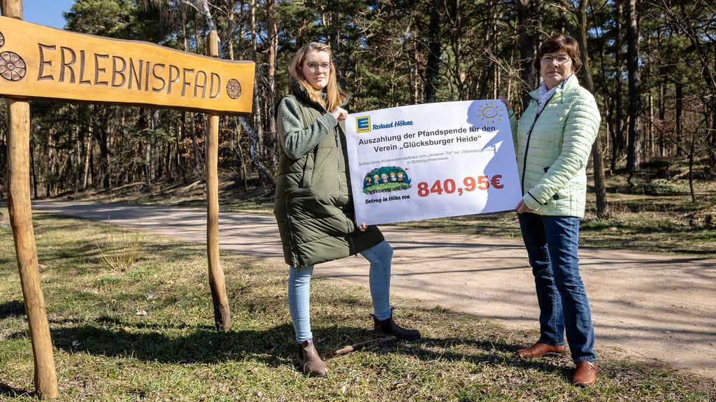 Edeka-Mitarbeiterin Juliane Clemens (l.) übergibt am Tor zur Heide in Jessen symbolisch die Pfandspende an Vereinsmitglied Petra Räbiger.