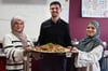 Yara Sadoo (li.), Mohamed Ali und Soleen Saado haben beim Fastenbrechen teilgenommen. In der Hand halten sie Fattoush, einen Salat mit Fladenbrot-Chips.