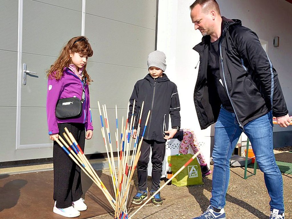 Maria und Lio spielen mit Steve Daniel Riesenmikado.