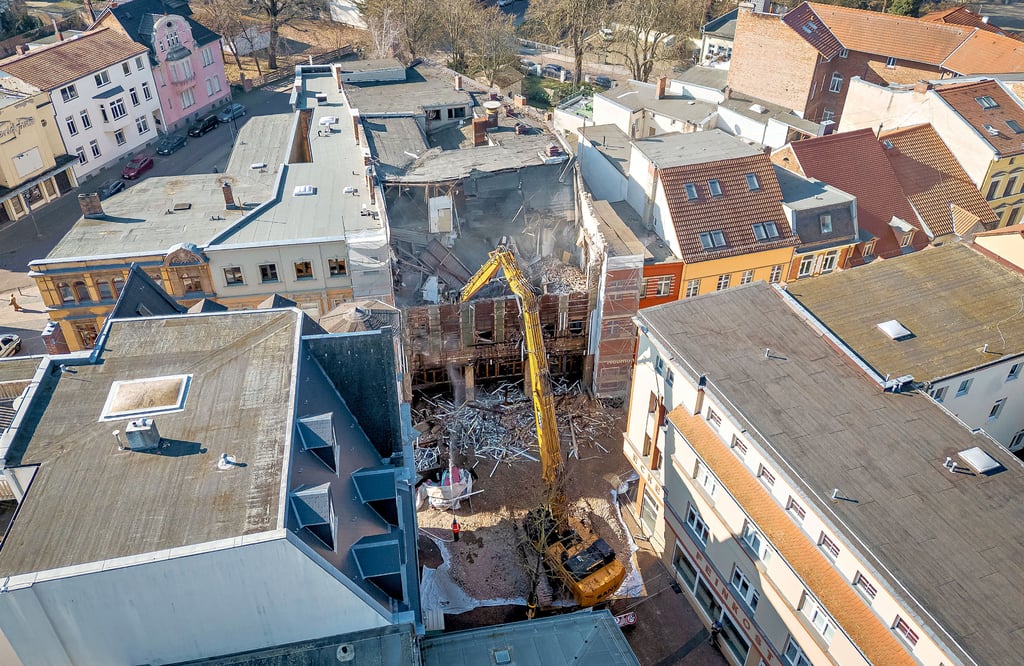 Das Luftbild  zeigt den Abrissbagger, der von der Neustädter Straße aus das frühere Kaufhaus in der Schalaunischen Straße abreißt.