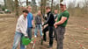 Ali, Yannik, Amalia, Friedrich und Jesper von der Klasse 9a des Liboriusgymnasiums  werden von Azubi  Leon Förster (r.) beim Bäume pflanzen unterstützt.