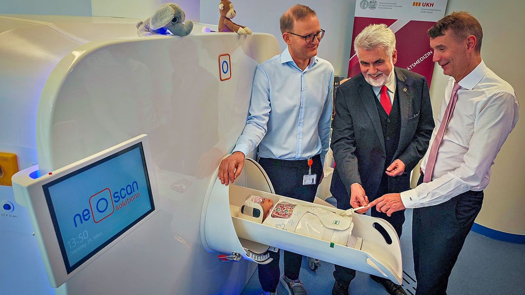 Die Mediziner Roland Haase (li.) und Walter Wohlgemuth (re.) zeigen Wissenschaftsminister Armin Willingmann, wie das MRT für Babys funktioniert.