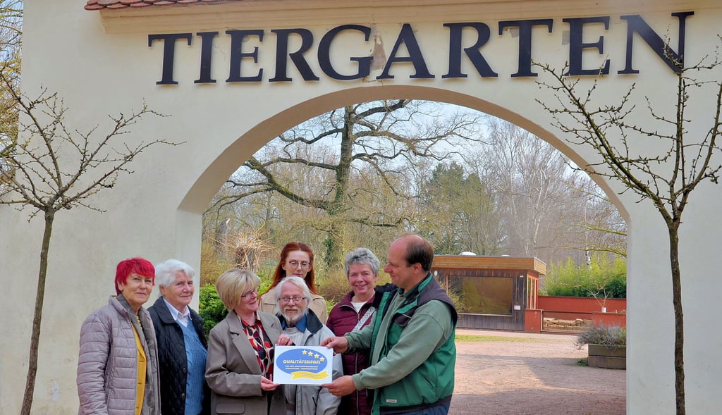 Cornelia Stegemann (3. von links) übergibt Tiergartenleiter Andreas Filz (rechts) das Siegel.
