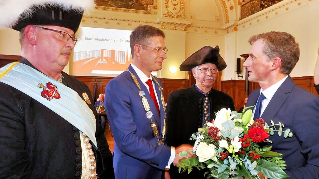 Eingerahmt von Halloren hat Stadtratsvorsitzender Jan Riedel (rechts) Alexander Vogt als neuen OB in Halle vereidigt.