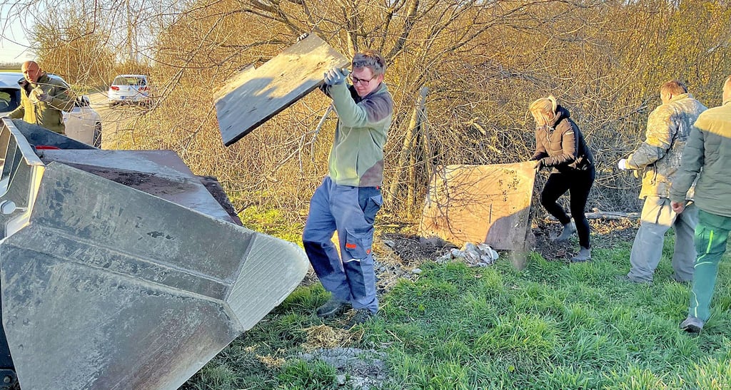 Den Haufen mit weggeworfene Siebdruckplatten laden Jäger vom Hegering in die Schaufel des Manitu-Laders.