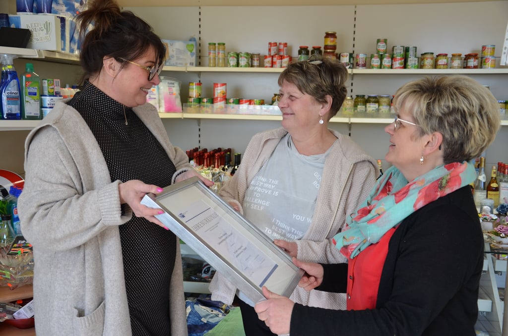 Kathleen Pielert (links) überreicht an Silke von Kalnassy-Klindt  (rechts) und deren Schwester Heike Eisele im Warmsdorfer Tante-Emma-Laden die "Durchhalte"-Ehrenurkunde der IHK Halle-Dessau.