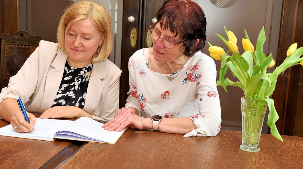 Die Preisträgerinnen Michaela Hamel (links) und Karin Keller tragen sich in das neue Goldene Besucherbuch der Stadt ein.
