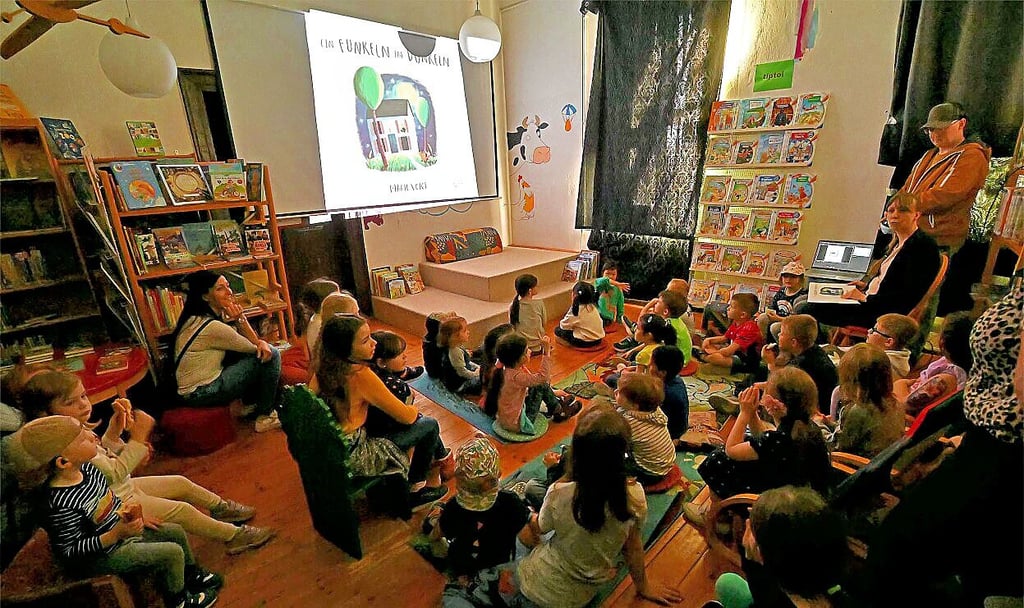 In der abgedunkelten Kinderbibliothek liest Marion Rauter (re.).