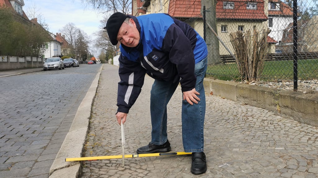 Bernhard Haberkorn misst nach: Bis zum 12 Zentimeter tief sind die Löcher in der Mozartstraße. 