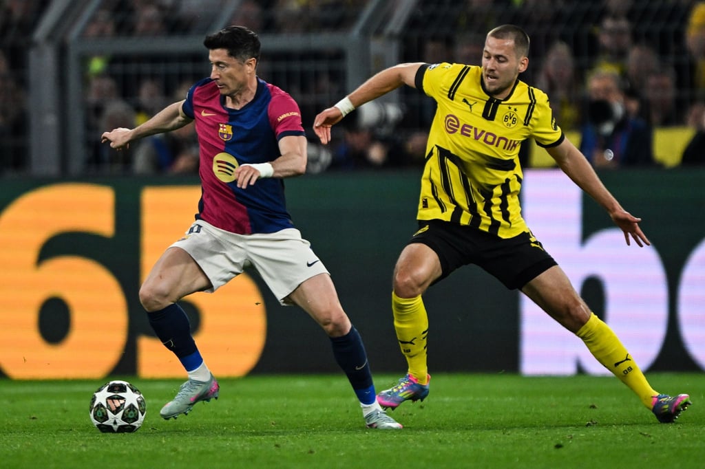 Barcelonas Robert Lewandowski (l) und Dortmunds Waldemar Anton kämpfen um den Ball.