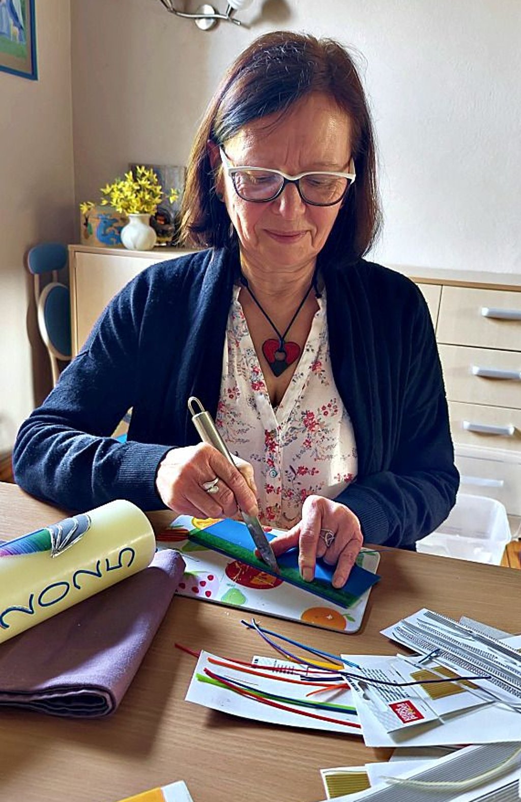 Birgit Eckert schneidet ein Schmuckelement aus einer Wachstafel.