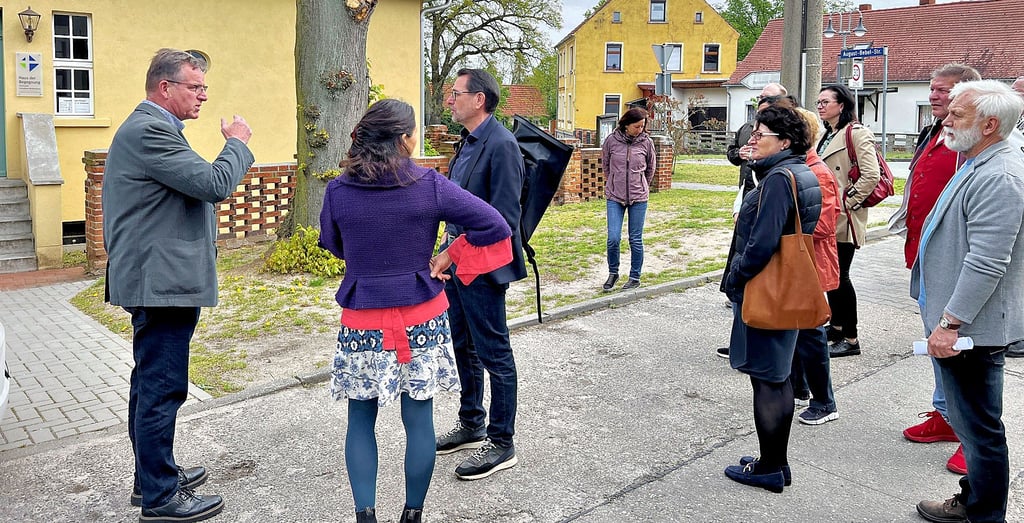 Der stellvertretende Bürgermeister Uwe Engel (links) führte die Delegation durch Schollene. Hier sind die Gäste am Haus der Begegnung, in dem sich die Paramentik-Werkstatt von Gudrun Willenbockel befindet.