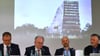 Der Ostbeauftragte Carsten Schneider, Sachsen-Anhalts Ministerpräsident Reiner Haseloff (CDU), Architekt Jan Musikowski und Landschaftsarchitekt Tobias Micke sitzen vor einem Entwurf des Zukunftszentrums in Halle.