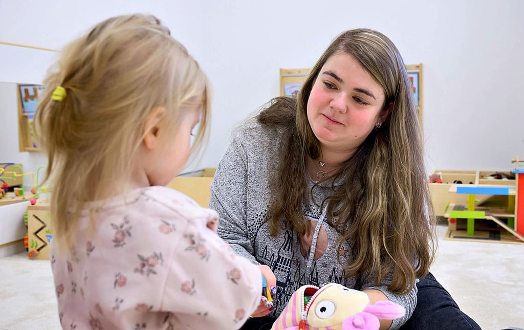 Fachkräftemangel: Brenda Hornos Justicia, Erzieherin aus Spanien, spielt in einer Kita in Langenhagen mit einem zweijährigen Mädchen. Die Region Hannover hat Fachkräfte aus Spanien angeworben, um die Personalnot in Kitas zu bekämpfen. In Tangerhütte werden Erzieherstunden gekürzt.
