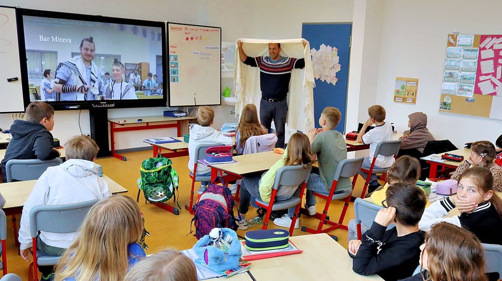 Nir Lasri zeigt den Schülern der Grundschule Welsleben die jüdische Gebetskleidung.