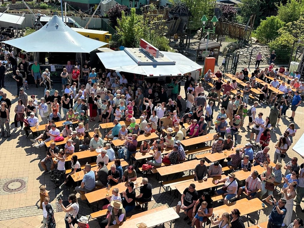 Blick auf viele Gäste, die vor der Hauptbühne des Walpurgismarktes sitzen und stehen - und oft auch mitsingen.