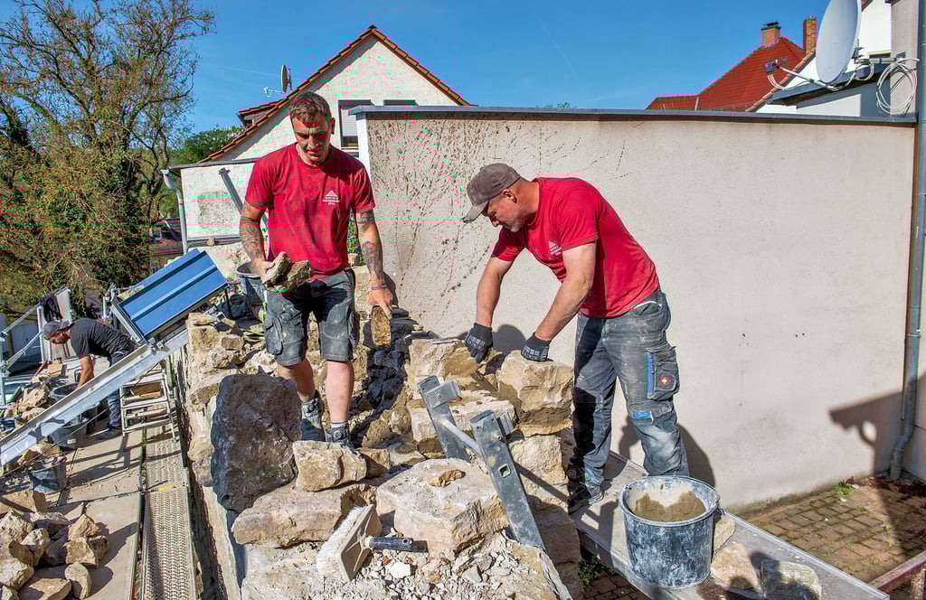 Mitarbeiter der Firma Elektro- und Sanierungsbau Bösel aus Freyburg setzen die Stadtmauer am Weg „Am Graben“ instand.