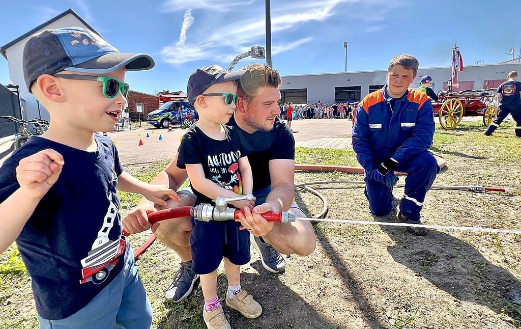 Fabian, Rafael und Vater Clemens Berndt (v.l.) probierten sich zum Feuerwehrfest beim Löschen.