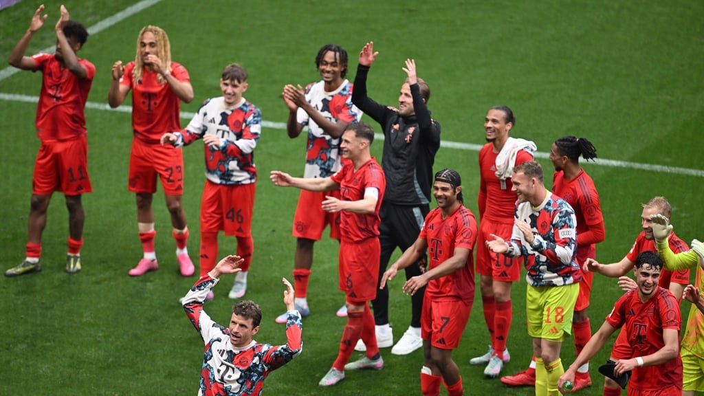 Thomas Müller (vorne) stimmte nach dem 3:3 in Leipzig die Welle mit den Fans an.