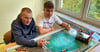 Maxi  und Tom (16 und 15, von links) haben die Höhlenmalerei eines Mammuts analysiert und ihre Erkenntnis auf das dazugehörige Rollposter gemalt. 