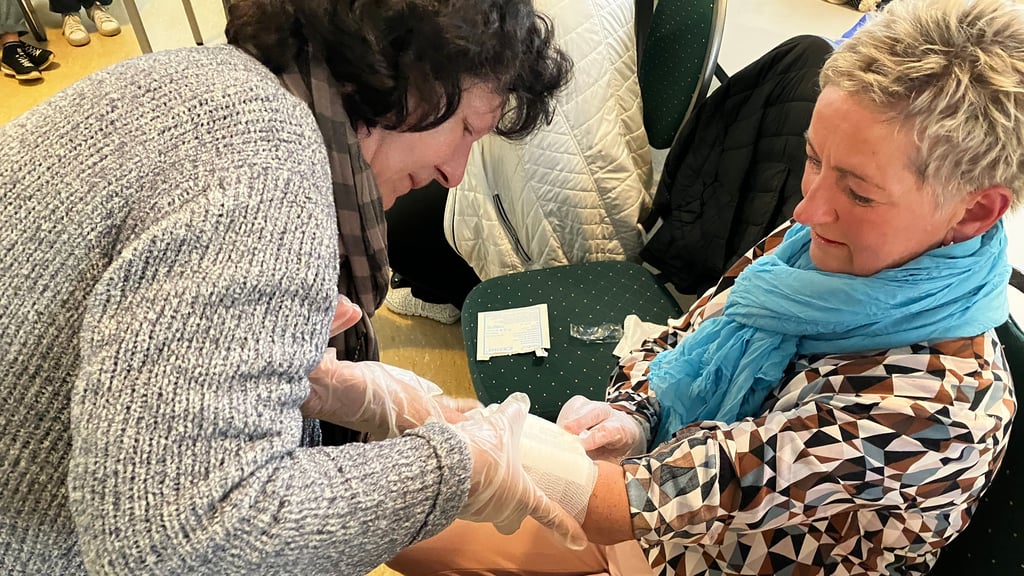 Doris Marquardt legt Karina Golembski einen Druckverband an.