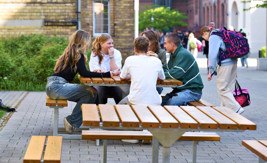 Diese Sitzgruppen sind vor allem für die jüngeren Gymnasiasten gedacht, die hier frühstücken. Fürs Foto haben Elftklässler die Bänke getestet.