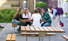Diese Sitzgruppen sind vor allem für die jüngeren Gymnasiasten gedacht, die hier frühstücken. Fürs Foto haben Elftklässler die Bänke getestet.