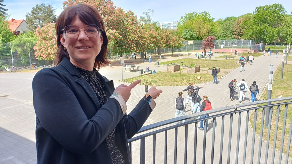 Schulleiterin Jessika Hellge zeigt auf die Fläche des Schulhofs, auf der das Haus der Gewerke entstehen soll.